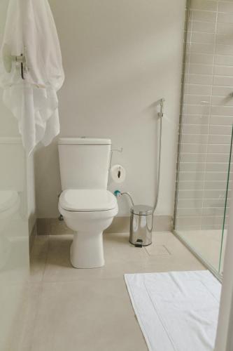 a white bathroom with a toilet and a shower at Pousada Paraiso in Alto Paraíso de Goiás