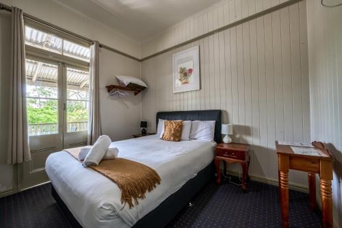 a bedroom with a bed and a table and a window at Yandina Hotel in Yandina