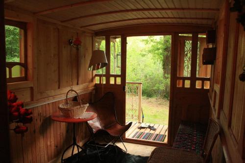 une petite pièce avec une table et des chaises dans une cabine dans l'établissement Roulotte en Sologne, à Saint-Laurent-Nouan