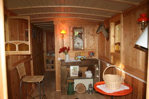 Saint Laurent NouanにあるRoulotte en Sologneの小さな家の中にある小さな部屋で、テーブルと椅子が備わります。