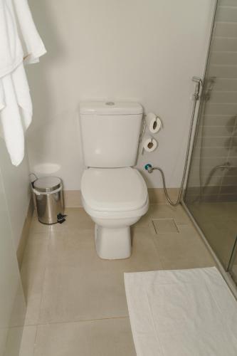 a bathroom with a white toilet and a shower at Pousada Paraiso in Alto Paraíso de Goiás