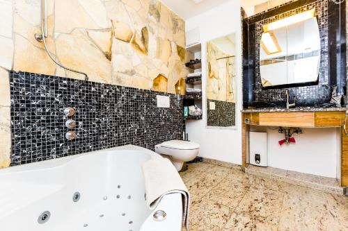 a bathroom with a tub and a toilet and a sink at Oase der Ruhe in Bornheim