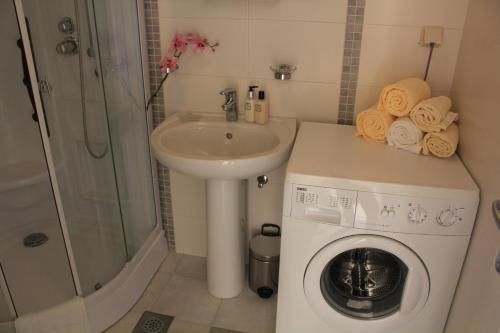 baño pequeño con lavadora y lavamanos en Apartment Marlais A, en Cavtat