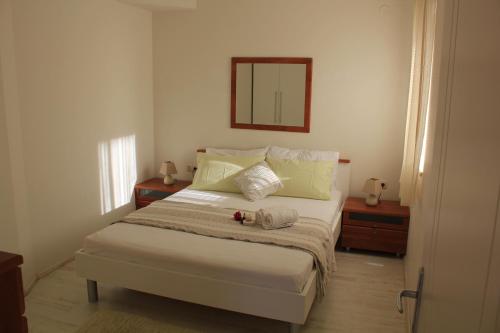 1 dormitorio con 1 cama con espejo en la pared en Apartment Marlais A, en Cavtat