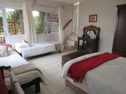 a bedroom with two beds and a stair case at Rose and Ale Self Catering Units in Gonubie