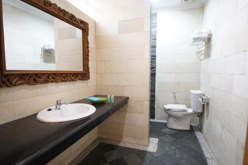 ein Bad mit einem Waschbecken und einem WC in der Unterkunft Hotel New Puri Garden in Kalibanteng-lor