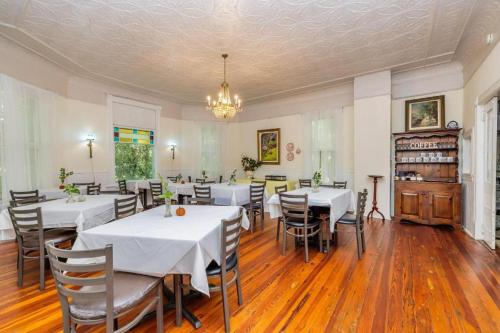 een eetkamer met tafels en stoelen en een kroonluchter bij Veranda Historic Inn 