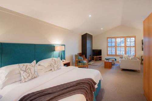 a large bedroom with a large bed with a blue headboard at Spicers Vineyards Estate in Pokolbin