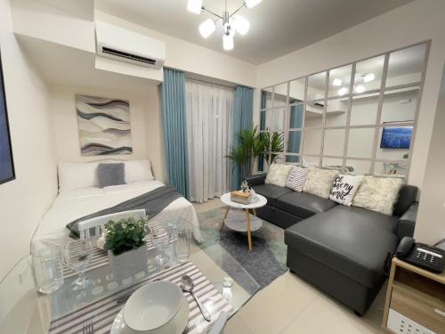 a bedroom with a bed and a couch at Inspiria Condo Units beside Abreeza Mall Davao in Davao City
