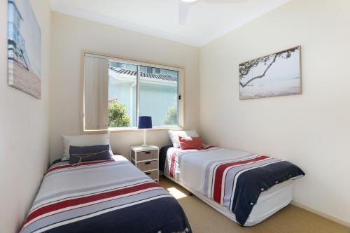a bedroom with two beds and a window at Blue Paradise on Coorilla in Hawks Nest