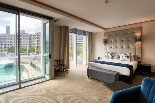 een hotelkamer met een bed en een groot raam bij Marsden Viaduct Hotel in Auckland