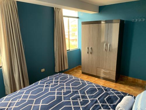 1 dormitorio con paredes azules, 1 cama y armario en El Viejo Roble, en Cusco