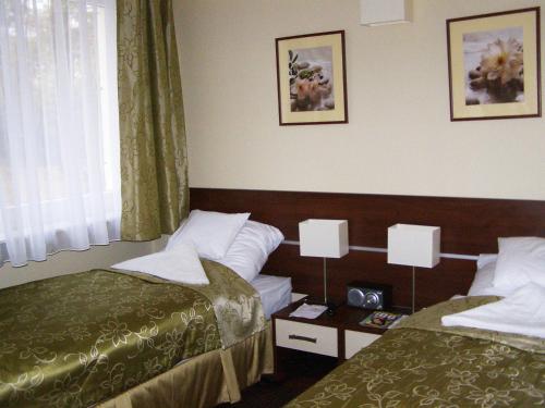 ポルチンズドロイにあるUzdrowisko Polczyn SPA Zaciszeのベッド2台と窓が備わるホテルルームです。