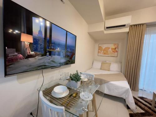 a room with a bed and a tv on a wall at Inspiria Condo Units beside Abreeza Mall Davao in Davao City