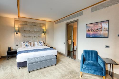 a hotel room with a bed and a blue chair at Marsden Viaduct in Auckland