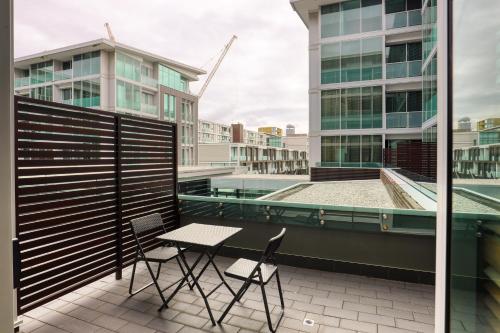 a table and chairs on a balcony with buildings at Marsden Viaduct Hotel in Auckland