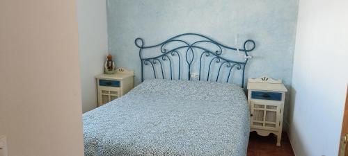 1 dormitorio con 1 cama azul y 2 mesitas de noche en Chalet independiente con vistas en urbanización privada en Peñíscola