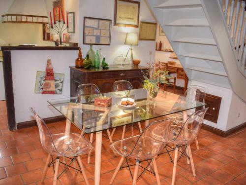 une salle à manger avec une table et des chaises en verre dans l'établissement Gîte douillet en forêt d'Amboise, parc boisé 2.5 ha, cheminée, vélos, WiFi, jardin privé, animaux acceptés - FR-1-381-457, à Souvigny-de-Touraine