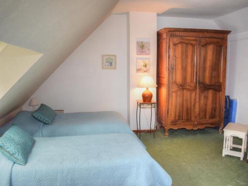 1 dormitorio con 1 cama azul y armario de madera en Gîte Souvigny-de-Touraine, 3 pièces, 6 personnes - FR-1-381-457, en Souvigny-de-Touraine