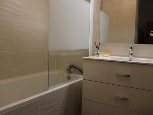 une salle de bain avec une baignoire et un lavabo et une baignoire dans l'établissement Studio cabine 4 pers. à Biscarrosse Plage, face océan, ménage inclu - FR-1-319-218, à Biscarrosse-Plage