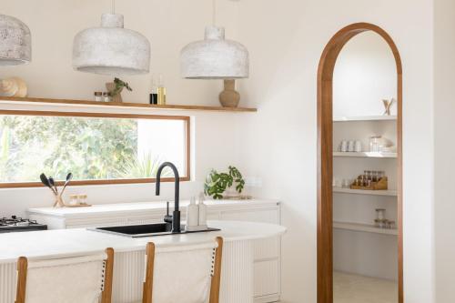 una cucina con lavandino e specchio di Villa Zyloh Sunset - New, Luxury, Ocean View Villa, Bingin a Uluwatu