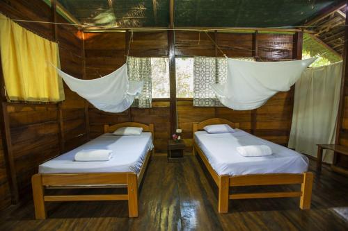 two beds in a room with nets over them at Majacho`s House in Puerto Maldonado