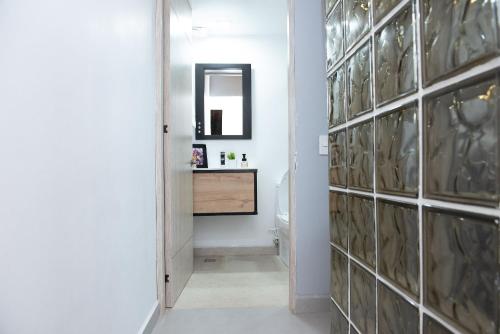 a hallway with a bathroom with a sink and a mirror at El Cielo en la Vereda Barroblanco de Santa Elena in Medellín