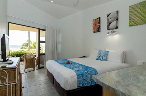 a bedroom with a bed and a view of the ocean at Club Raro Resort- Adults Only in Rarotonga