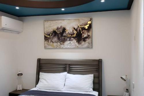 a bedroom with a bed with a painting on the wall at RH/Los angeles (#1) front of airport in San Juan