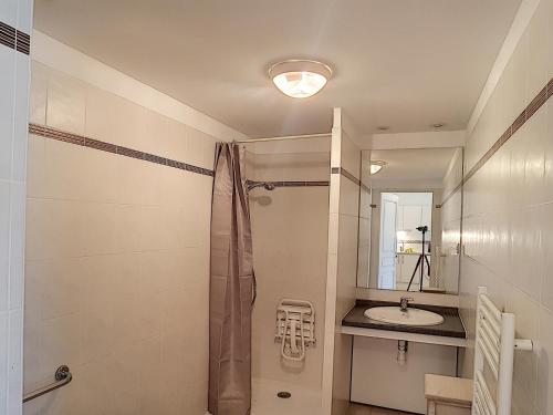 une salle de bain avec douche et lavabo dans l'établissement Appartement F2 climatisé avec terrasse, proche centre-ville et thermes, animaux acceptés - FR-1-451-117, à Lamalou-les-Bains