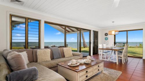 a living room with a couch and a table at Sea Cottage - Beachside Paradise in Beachmere