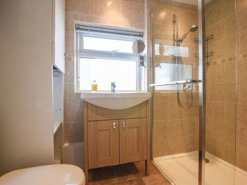 een badkamer met een wastafel, een toilet en een raam bij Okanagan in Lyme Regis
