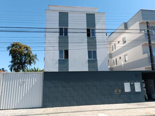 a white building with a fence in front of it at Apartamento Inteiro jardim Iririú in Joinville