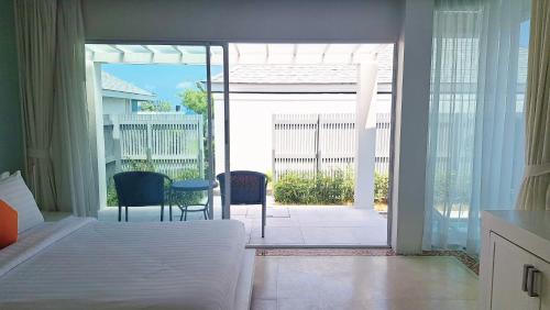 a bedroom with a bed and a view of a patio at Samui Resotel Beach Resort in Chaweng