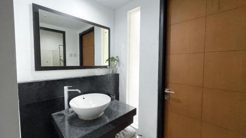 a bathroom with a sink and a mirror at LPP Convention Hotel Demangan in Yogyakarta