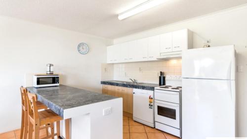 una cucina con mobili bianchi e un frigorifero bianco di Pacific Breakers Seaside Escape a Woorim