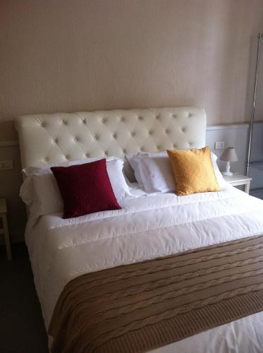 1 cama blanca grande con varias almohadas en B&B Le Grazie, en Bérgamo