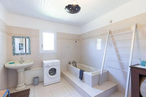 a bathroom with a washing machine and a sink at JARDIN SECRET, Bas de villa TOUT CONFORT in Le Tampon