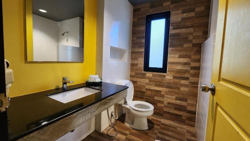 a bathroom with a sink and a toilet and a mirror at Pattaya Garden Resort in North Pattaya