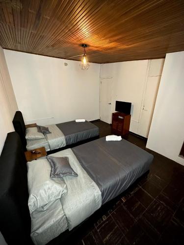a bedroom with two beds and a television in it at H&L BOUTIQUE in Bogotá