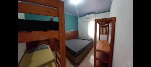 a small room with two bunk beds and a bed at Casa simples e aconchegante em Boracéia Bertioga SP in Bertioga