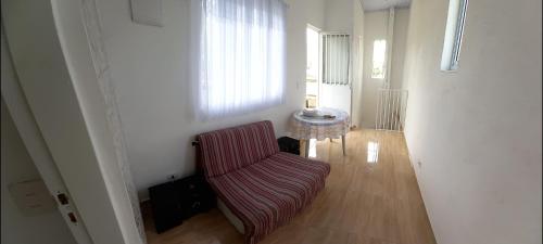 a living room with a chair and a table at Casa simples e aconchegante em Boracéia Bertioga SP in Bertioga
