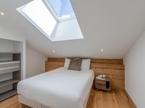 sypialnia z łóżkiem i świetlikiem w obiekcie Penthouse rénové à Courchevel avec parking et Wi-Fi - FR-1-563-130 w Courchevel