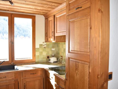 une cuisine avec des armoires en bois et une fenêtre dans l'établissement Appartement cosy 4 pièces, balcon, proche centre et téléphérique, face pistes de ski de fond - FR-1-464-214, à Pralognan-la-Vanoise