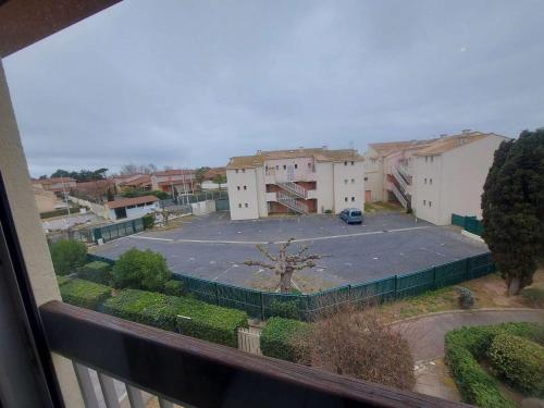 une vue d'un parking depuis un balcon dans l'établissement Studio Mezzanine pour 4 à Marseillan avec Parking Privé, TV et Cuisine Équipée - FR-1-326-783, à Marseillan