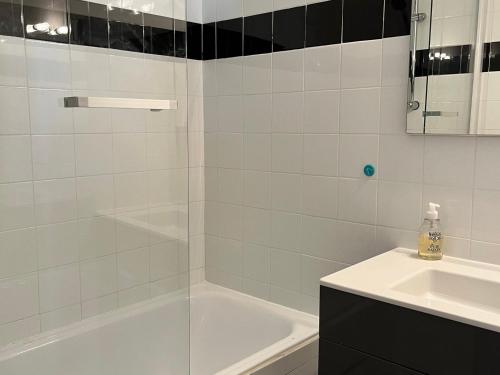 ein weißes Badezimmer mit einer Badewanne und einem Waschbecken in der Unterkunft Appartement Villard-de-Lans, 2 pièces, 4 personnes - FR-1-515-164 in Villard-de-Lans