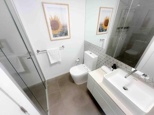 a bathroom with a toilet and a sink and a shower at Moonee Ponds Stylish Apartment - 415 in Melbourne