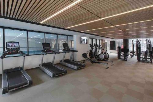 a gym with treadmills and elliptical machines at Moonee Ponds Stylish Apartment - 415 in Melbourne