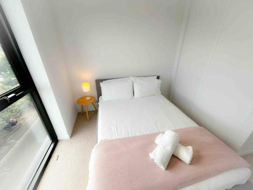 a small room with a bed and a window at Moonee Ponds Stylish Apartment - 415 in Melbourne