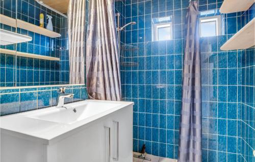 スケーエンにあるNice Home In Skagen With Wifiの青いタイル張りのバスルーム(シンク、シャワー付)